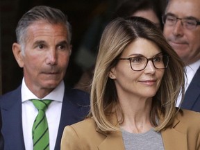 Trouble in paradise? Lori Loughlin, front, and husband, clothing designer Mossimo Giannulli, leave a Boston courthouse. THE ASSOCIATED PRESS files