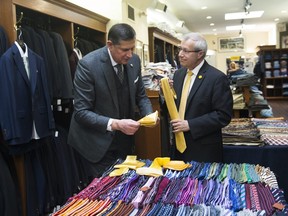 Vic Fedeli, right, Finance Minister of Ontario purchases a tie from Tomas Mihalik during a pre-budget photo opportunity in Toronto, on Tuesday