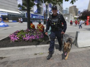 This Sun file photo shows a Toronto Police officer and his bomb-sniffing dog patrolling outside the Rogers Centre on Thursday, July 12, 2018. (Jack Boland/Toronto Sun/Postmedia Network)