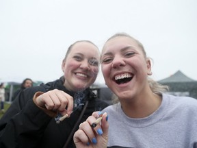 Morgan Brown(L) and Amanda Sinclair light up at Woodbine Park during the 4/20 celebration on Saturday, April 20, 2019. (Veronica Henri/Toronto Sun/Postmedia Network)