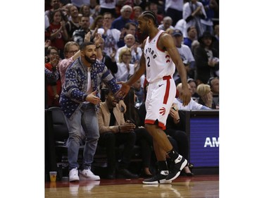 Toronto Raptors Kawhi Leonard SF (2) gets a low five from Drake as he exits the game during the second half in Toronto, Ont. on Saturday April 27, 2019. Jack Boland/Toronto Sun/Postmedia Network