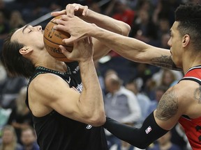 Minnesota Timberwolves' Dario Saric (left) fights for possession of the ball against Toronto Raptors' Danny Green on Tuesday night in Minneapolis. (AP PHOTO)
