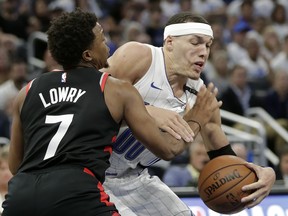 Orlando Magic's Aaron Gordon, right, struggles to get around Toronto Raptors' Kyle Lowry (7) during the second half in Game 3 of a first-round  playoff series, Friday(AP Photo/John Raoux)