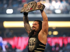 In this April 3, 2016, file photo, Roman Reigns holds up the championship belt after defeating Triple H during WrestleMania 32 at AT&;T Stadium in Arlington, Texas. (Jae S. Lee/The Dallas Morning News via AP, File)