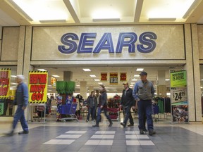 Shoppers walk by Sears department store with store closing signs at the Grand Teton Mall in Idaho Falls, Idaho on Black Friday, Nov. 23, 2018. (John Roark/The Post-Register via AP)
