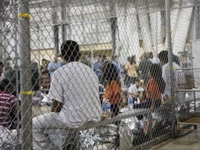 In this photo provided by U.S. Customs and Border Protection, people who've been taken into custody related to cases of illegal entry into the United States, sit in one of the cages at a facility in McAllen, Texas, June 17, 2018.