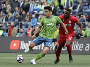 Seattle Sounders midfielder Kim Kee-Hee, (left) kicks the ball away from Toronto FC forward Jozy Altidore in Seattle Saturday. TFC lost 3-2. (AP)