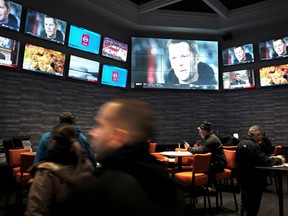 In this Jan. 28, 2019, file photo, patrons visit the sports betting area of Twin River Casino in Lincoln, R.I. (AP Photo/Steven Senne, File)