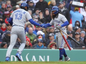 Lourdes Gurriel Jr. of the Toronto Blue Jays (left) celebrates with teammate Freddy Galvis after scoring on a steal of home against the Boston Red Sox during the fourth inning on April 9, 2019, at Fenway Park in Boston. (MADDIE MEYER/Getty Images)
