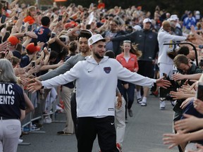 Ty Jerome and other members of the Virginia basketball team are welcomed by fans as they return home after their win of the championship in the Final Four NCAA college basketball tournament against Texas Tech, in Charlottesville, Va., Tuesday, April 9, 2019. (STEVE HELBER/AP)