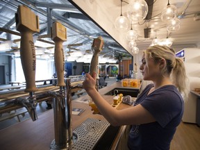 Natalie Scrivo pours Belgian Moon's seasonal offerings at Stackt, a culturural and community hub made entirely out of shipping containers in downtown Toronto on Monday, April 22, 2019. (Stan Behal/Toronto Sun/Postmedia Network)