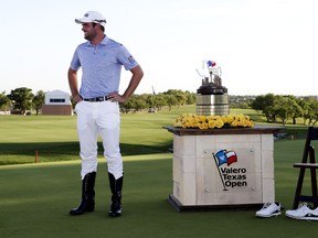 Corey Conners tries on a pair of cowboy boots that he was presented after winning the Texas Open on Sunday. Conners will be playing at the Master later this week. (AP Photo/Eric Gay)
