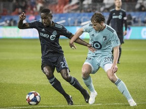 Toronto FC midfielder Richie Laryea battles for the ball with Minnesota United midfielder Rasmus Schuller last night at BMO Field.  
(Christopher Katsarov 
/The Canadian Press)