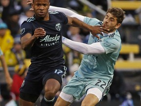 Columbus Crew defender Gaston Sauro (back) makes contact with Timbers forward Jeremy Ebobisse. The Timbers are playing 12 constitutive road games to start the season.  AP