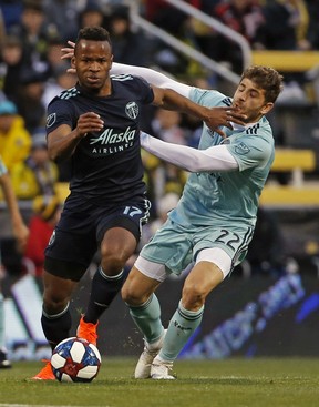 Columbus Crew defender Gaston Sauro (back) makes contact with Timbers forward Jeremy Ebobisse. The Timbers are playing 12 constitutive road games to start the season.  AP