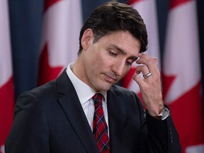 Prime Minister Justin Trudeau scratches his forehead as he listens to a question during an end of session news conference in Ottawa, Wednesday, Dec. 19, 2018.