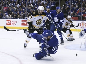 Defenceman Morgan Rielly, who played one of his finest games in a Leafs uniform on Sunday, hits the ice after blocking shot while Bruins Patrice Bergeron looks on. Veronica Henri/Toronto Sun/Postmedia Network)