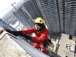 A Sky High Windows Services employee descends a 40-storey apartment building near Islington Ave. and Bloor St. W. on Wednesday, April 17, 2019. (Jack Boland/Toronto Sun/Postmedia Network)