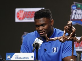 Duke freshman Zion Williamson sits behind the Oscar Robertson Trophy at a news conference where he was awarded the U.S. Basketball Writers Association College Player of the Year award on Friday in Minneapolis. (AP PHOTO)