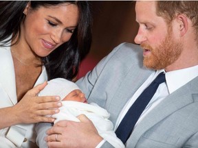 Britain’s Prince Harry, Duke of Sussex, and his wife Meghan, Duchess of Sussex, pose for a photo with their newborn baby son, Archie Harrison Mountbatten-Windsor, in St George’s Hall at Windsor Castle in Windsor, west of London on May 8, 2019.