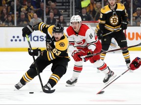 Boston Bruins Brad Marchand, left, handles the puck against Sebastian Aho of the Carolina Hurricanes during the first period in Game 2 of the Eastern Conference Final during the 2019 NHL Stanley Cup Playoffs at TD Garden on May 12, 2019 in Boston, Mass. (Bruce Bennett/Getty Images)