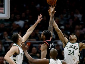 Kawhi Leonard of the Raptors attempts a shot against three Bucks — Brook Lopez (left), Khris Middleton and Giannis Antetokounmpo — in the third quarter of last night’s blowout in Milwaukee. Leonard finished the night with 31 points.  Jonathan Daniel/Getty Images