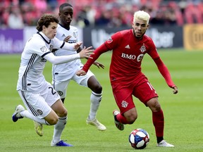 Philadelphia Union's  Brenden Aaronson (left) and Jamiro Monteiro pressure Toronto FC midfielder Alejandro Pozuelo during Saturday's game. (THE CANADIAN PRESS)