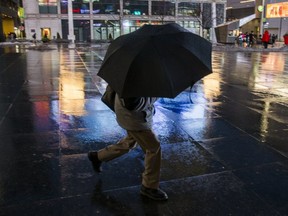 In this Toronto Sun file photo, a man walks with an umbrella at Yonge and Dundas Sts. (Ernest Doroszuk, Toronto Sun)