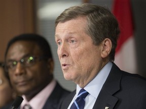 Mayor John Tory (front) is pictured speaking to the media with Councillor Michael Thompson next to him on April 19, 2019. (Stan Behal, Toronto Sun)