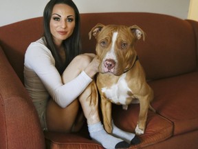 Jynnie Kent in her Oshawa apartment with one of her three dogs. (Veronica Henri, Toronto Sun)
