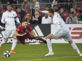 Toronto FC midfielder Jonathan Osorio gets tripped up by D.C. United defender Frederic Brillant during Wednesday's game. (THE CANADIAN PRESS)