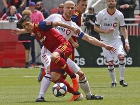 Toronto FC midfielder Michael Bradley battles for the ball with Real Salt Lake forward Jefferson Savarino during Saturday's game. (AP PHOTO)