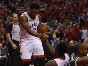 Toronto Raptors' Kyle Lowry helps teammate Pascal Siakim up during Tuesday's game. (JACK BOLAND/Toronto Sun)