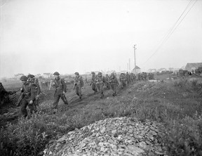 Canadian infantrymen heading to battle at dawn for Operation Spring in the south of Vaucelles, France, July 25, 1944.