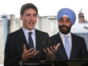 Prime Minister Justin Trudeau (L) delivers a press conference flanked by Minister of Innovation, Science and Economic Development Navdeep Singh Bains on May 16, 2019, in Paris. (JACQUES DEMARTHON/AFP/Getty Images)