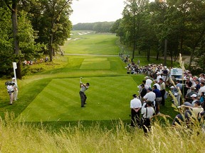 In this Tuesday, June 11, 2002, file photo, Tiger Woods hits his tee shot on the fourth hole during a practice round at the U.S. Open Golf Championship at the Black Course of Bethpage State Park in Farmingdale, N.Y.