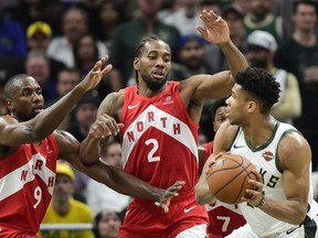 Raptors' Serge Ibaka (9) and  Kawhi Leonard (2) double team Milwaukee Bucks forward Giannis Antetokounmpo (34) during second half action in Game 5 of the NBA Eastern Conference final in Milwaukee on Thursday, May 23, 2019. THE CANADIAN PRESS/Frank Gunn