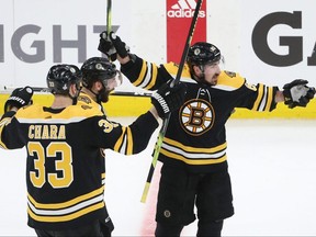 Bruins forward Brad Marchand (right) is congratulated by teammates Patrice Bergeron (centre) and Zdeno Chara (lef) after scoring a third period empty-net goal against the Blues in Game 1 of the Stanley Cup Final at TD Garden in Boston on Monday, May 27, 2019.