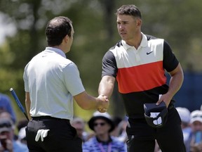 Brooks Koepka, right, shakes hands with Francesco Molinari, after finishing the first round of the PGA Championship at Bethpage Black in Farmingdale, N.Y., Thursday, May 16, 2019.