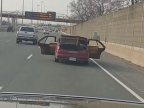 Hamilton police say a car with its doors open travelling on the QEW in a viral video is linked to a series of break and enters. (Facebook/David Fafinski)