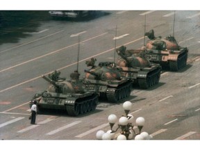 FILE - In this June 5, 1989 file photo, a Chinese man stands alone to block a line of tanks heading east on Beijing's Changan Blvd. in Tiananmen Square. The man, calling for an end to the recent violence and bloodshed against pro-democracy demonstrators, was pulled away by bystanders, and the tanks continued on their way. Over seven weeks in 1989, student-led pro-democracy protests centered on Beijing's Tiananmen Square became China's greatest political upheaval since the end of the Cultural Revolution more than a decade earlier. (AP Photo/Jeff Widener)
