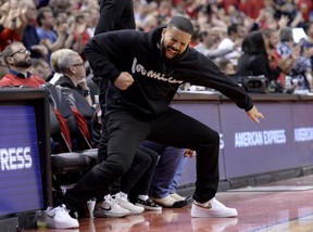 Toronto-born performer Aubrey “Drake” Graham reacts to a three point basket courtside during second half NBA Eastern Conference finals action against the Milwaukee Bucks, in Toronto on Saturday, May 25, 2019. (THE CANADIAN PRESS/Nathan Denette)