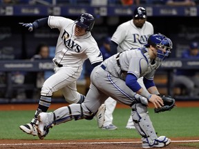 Tampa Bay Rays' Avisail Garcia, left, scores around Toronto Blue Jays catcher Danny Jansen on an inside-the-park home run during the third inning of a baseball game, Tuesday, May 28, 2019, in St. Petersburg, Fla.