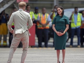Britain's Prince Harry and Meghan, Duchess of Sussex react before boarding their flight from Nadi, Fiji. Sunday, May 19, 2019 marks the first wedding anniversary of the besotted couple.