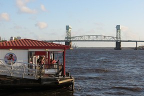 Patrons at Anne Bonny’s Bar and Grill look out over Cape Fear River towards Cape Fear Memorial Bridge in Wilmington, N.C. (Ian Robertson)