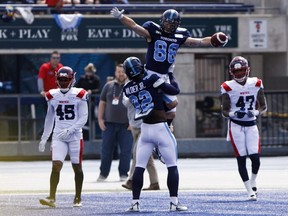 Argonauts' James Wilder Jr. (32) lifts up wide receiver Jimmy Ralph after a touchdown during pre-season CFL action against the Alouettes at Varsity Stadium in Toronto on Thursday, May 30, 2019.