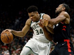 Bucks' Giannis Antetokounmpo (left) dribbles the ball while being guarded by Raptors' Kawhi Leonard in the fourth quarter during Game 2 of the NBA's Eastern Conference Finals at the Fiserv Forum in Milwaukee on Friday, May 17, 2019.