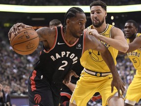 Toronto Raptors forward Kawhi Leonard (2) moves past Golden State Warriors guard Klay Thompson (11) during first half NBA basketball action in Toronto on Thursday Nov. 29, 2018. (Nathan Denette/The Canadian Press)