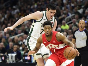 Bucks’ Ersan Ilyasova (left) defends against Raptors’ Kyle Lowry during Game 5 on Friday night in Milwaukee. (THE CANADIAN PRESS)