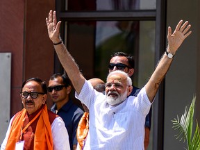 Indian Prime Minister Narendra Modi waves to supporters at the Trade Facilitation Centre and Crafts Museum after offering prayers at the famous Kashi Vishwanath temple, in Varanasi on May 27, 2019.